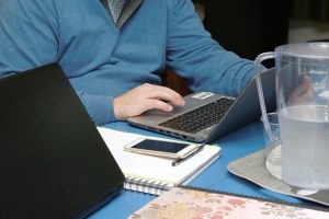 télétravail et immobilier-homme assis à son bureau devant un pc portable
